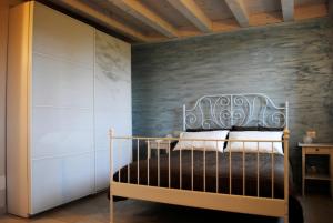 a bedroom with a bed with a gray wall at Bed And Breakfast Castello in Villafranca di Verona