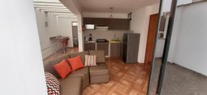 ein Wohnzimmer mit einem Sofa und einer Küche in der Unterkunft Departamento en el centro de San Borja (Rubens) in Lima