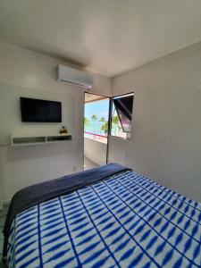 ein Schlafzimmer mit einem Bett und einem großen Fenster in der Unterkunft Vista pro mar in Maceió