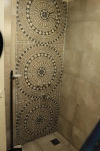 a shower stall with a tiled wall with a shower door at Hostería Altea in Monte Hermoso