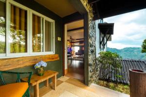 een huis met een balkon met een tafel en stoelen bij West 35 Eco Mountain Resort in Balamban