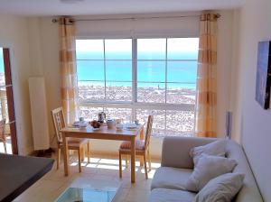 sala de estar con mesa y ventana grande en Apartamento Paraíso, en Costa Calma