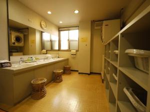 
a kitchen with a refrigerator and a sink at Hotel Route-Inn Kamisuwa in Suwa
