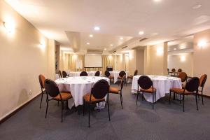 einen Konferenzraum mit Tischen, Stühlen und einem Podium in der Unterkunft Quality Hotel Ambassador Perth in Perth