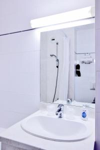 a white bathroom with a sink and a shower at The Originals City, Hôtel La Maison de Lise, Mulhouse Illzach in Illzach +15 photos