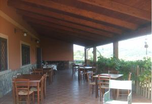 a restaurant with wooden tables and chairs in a building at Grappoloduva B&B in Solopaca