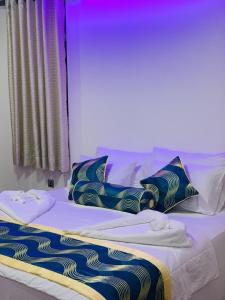 Cama con sábanas y almohadas azules y blancas en Venus Inn Nuwara Eliya, en Nuwara Eliya