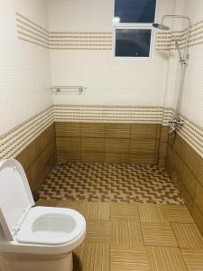 baño con aseo y suelo de baldosa. en Venus Inn Nuwara Eliya, en Nuwara Eliya