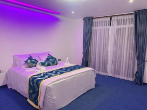 1 dormitorio con 1 cama grande con iluminación púrpura en Venus Inn Nuwara Eliya, en Nuwara Eliya