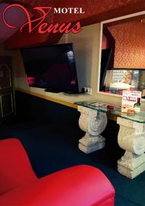 a desk with a tv and a red chair at Auto Hotel Venus in Xalapa