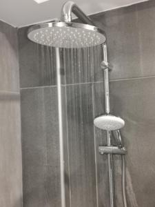 een douche met een douchekop in de badkamer bij Shalos Studios in Ayia Napa