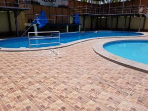 a large swimming pool with a brick walkway around it at Keylas Hotel in Ica