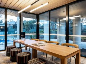a conference room with a wooden table and chairs at Mercure Sydney Rouse Hill in Kellyville