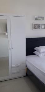 a small bedroom with a bed and a cabinet at Vida View Apartement, Tower Asthon Unit 20 P in Makassar +10 photos