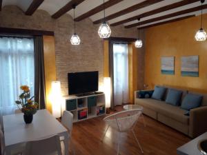 a living room with a couch and a tv at Espai One Valencia in Valencia