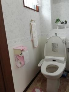 a white bathroom with a toilet and a sink at FukuokaKoryou GuestHouse in Fukuoka