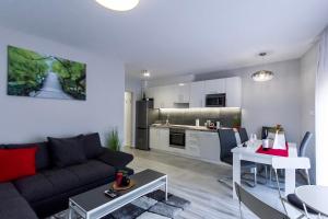 sala de estar con sofá y cocina en Grey Suites Pécs en Pécs