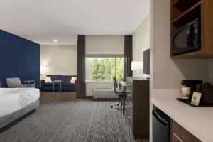 a hotel room with a bed and a desk at La Quinta by Wyndham Rock Hill in Rock Hill