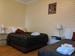 1 dormitorio con 2 camas y toallas. en Bondi Motel, en Moree