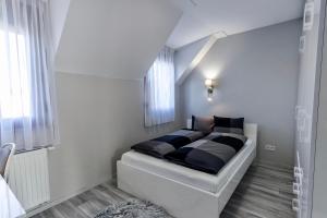 a bedroom with a bed with black and white at Grey Suites Pécs in Pécs