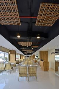 a dining room with tables and chairs and black ceilings at Whiz Prime Hotel Basuki Rahmat Malang in Malang