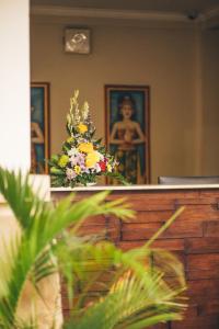 un jarrón de flores sentado en la parte superior de un tribunal en The Niche Bali, en Legian