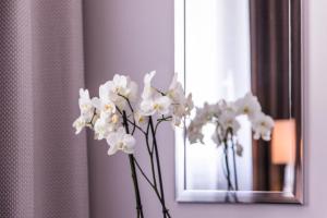 a white vase filled with flowers sitting on a window sill at Hôtel des Augustins in Aix-en-Provence