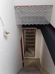Cette chambre dispose d'un escalier avec une étagère et une fenêtre. dans l'établissement FukuokaKoryou GuestHouse, à Fukuoka