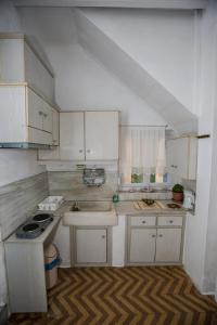 a kitchen with white cabinets and a sink at Hermoupolis Syros Maisonette in Ermoupoli