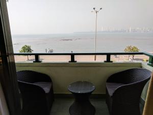 a balcony with chairs and a view of the beach at Sea Green Hotel in Mumbai