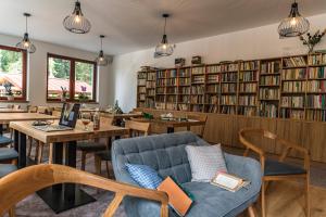a restaurant with tables and chairs and bookshelves at Hotel Jasná in Belá