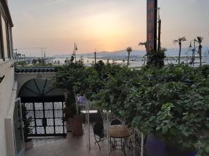d'une terrasse avec une table et des chaises et le coucher de soleil en arrière-plan. dans l'établissement Marco Polo, à Tanger