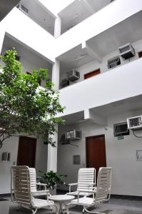 a room with chairs, tables, and a large window at Hotel Sol Centro (Adults Only) in Goiânia