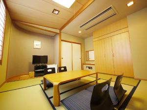 - un salon avec une table et des chaises en verre dans l'établissement Hotel Route-Inn Seibu Chichibu Ekimae, à Chichibu