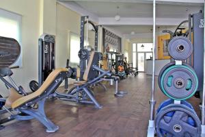Un gimnasio con varios equipos de ejercicio en una habitación. en Апартаменты в комплексе Caesar Resort & Spa, en Trikomo 29 fotos más