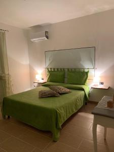 フォイアーノ・デッラ・キアーナにあるIl Falcoのベッドルーム1室(緑色のベッド1台、ランプ2つ付)