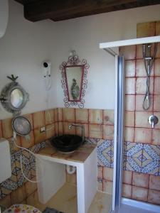 uma casa de banho com um lavatório e um espelho na parede em Atollo em Lipari