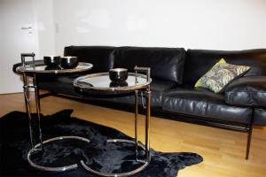 ein Wohnzimmer mit 2 Tischen und einem Sofa in der Unterkunft Casa Augusta - Urban Living in Trier