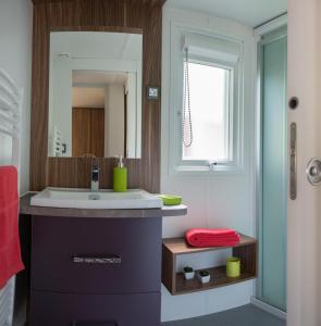 a bathroom with a sink and a mirror at Camping Officiel Siblu Domaine de Kerlann in Pont-Aven