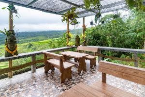 
a patio area with chairs, tables, and umbrellas at Pondok Nyoman in Bedugul
