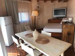 a kitchen with a table and a room with a bed at Sa Codina in Marina di Portisco