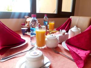 a table with breakfast foods and orange juice on it at Les Acacias Hotel Djibouti in Djibouti