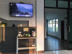 uma sala de estar com televisão na parede em The Like hotel em Udon Thani