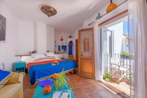 a bedroom with a blue bed and a balcony at Hotel Los Castaños in Cartajima