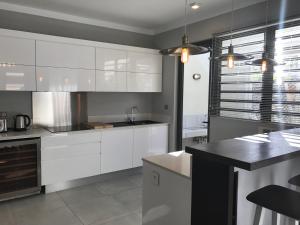 a kitchen with white cabinets and a black counter top at Luxury Villas at Royal Park in Balaclava