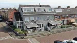 een vrouw staat voor een gebouw bij Hotel De Koningshof in Noordwijk aan Zee