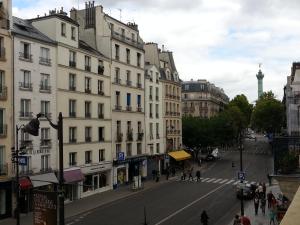 a city street with buildings and people walking on the street at Hôtel De La Herse d'Or in Paris