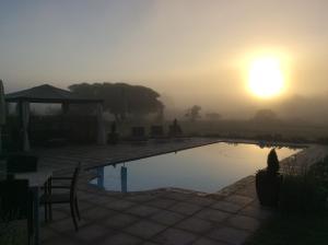 un amanecer sobre una piscina con el sol en el cielo en Kingston Farm, en Bathurst