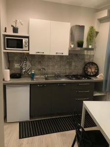 a kitchen with a sink and a microwave at TaoZen Apartments in Taormina