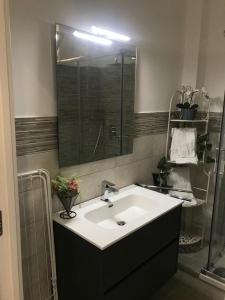 y baño con lavabo blanco y espejo. en TaoZen Apartments, en Taormina